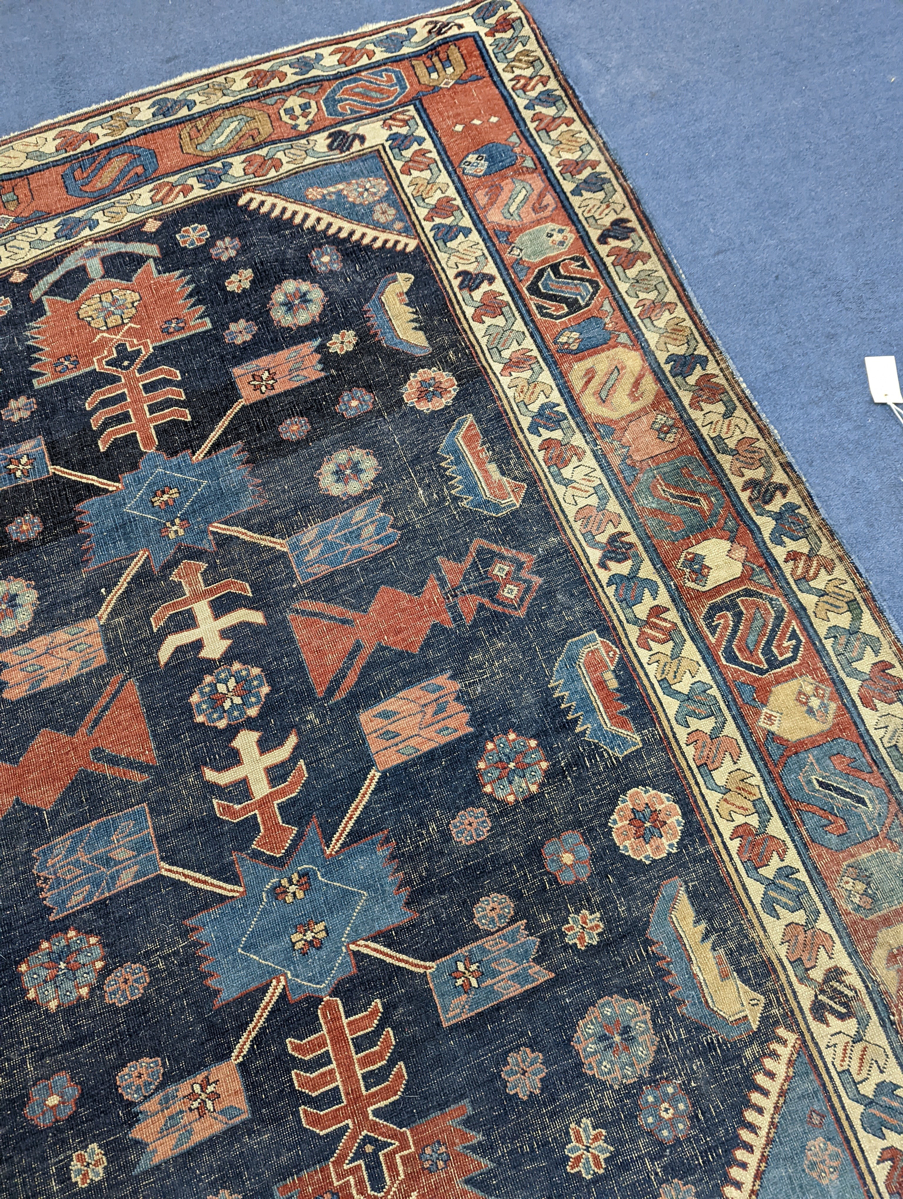 An antique Caucasian blue ground rug (worn), 200 x 148cm